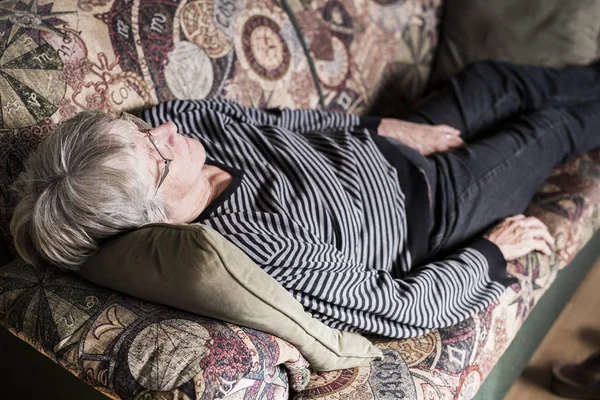 Senior mulher relaxante no sofá — Fotografia de Stock