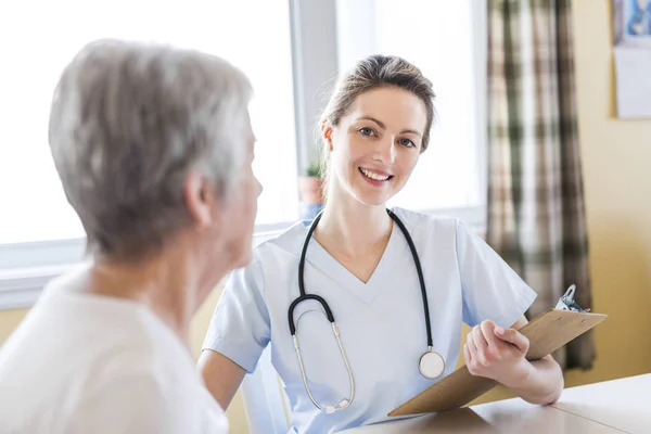 Seniorin mit Pflegerin zu Hause — Stockfoto