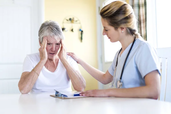 Senior woman with her caregiver at home — Stock Photo, Image