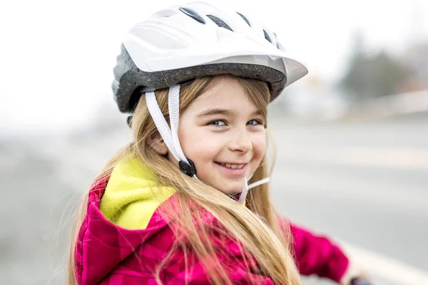 Bambina in bicicletta in una città — Foto Stock