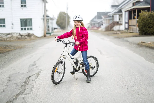 Bambina in bicicletta in una città — Foto Stock