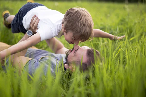 Far och son ha roligt utomhus i ängen — Stockfoto