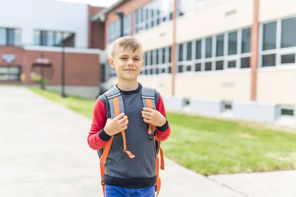 Gran retrato del alumno de la escuela fuera del aula llevando bolsas — Foto de Stock