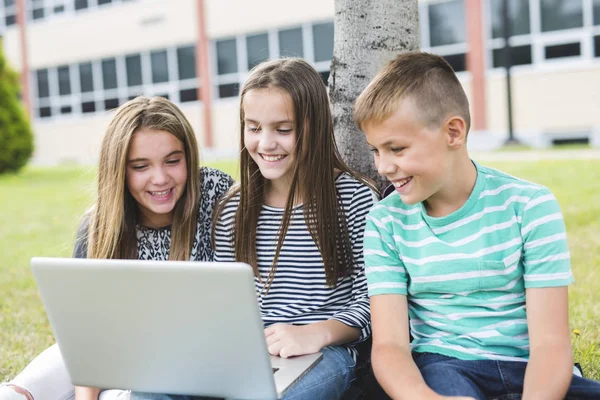 Enfants d'âge préscolaire en dehors de la salle de classe avec ordinateur portable — Photo