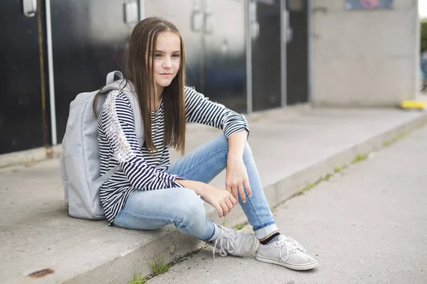 Aluno da escola primária lá fora carregando mochila — Fotografia de Stock