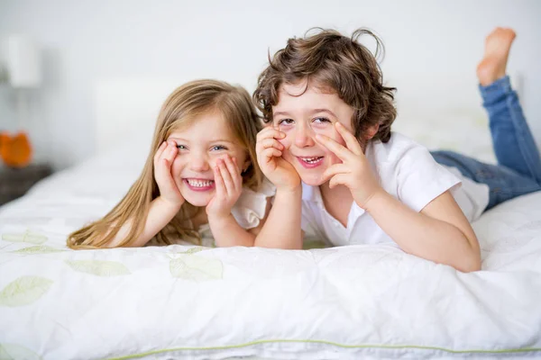 Irmão e irmã relaxando juntos na cama — Fotografia de Stock