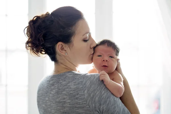 Felice madre che tiene adorabile bambino in salotto — Foto Stock