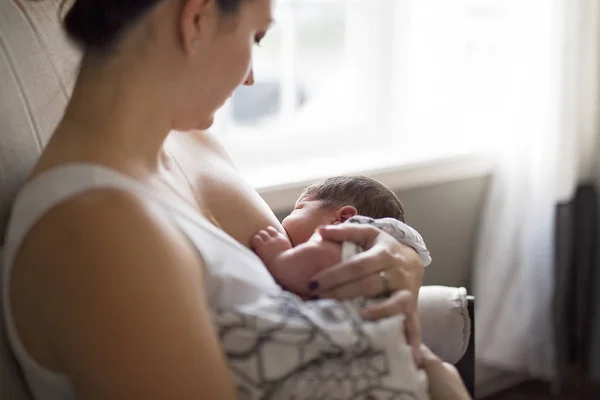 Madre che allatta il suo bambino in braccio . — Foto Stock