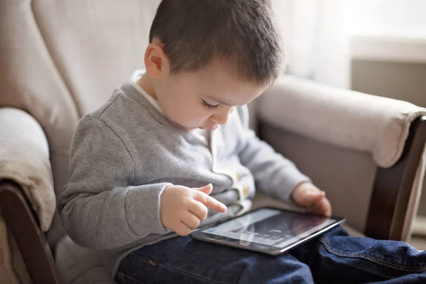 Menino usando um tablet digital sentar na sala de estar — Fotografia de Stock