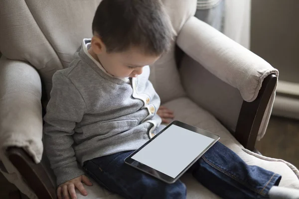 Menino usando um tablet digital sentar na sala de estar — Fotografia de Stock