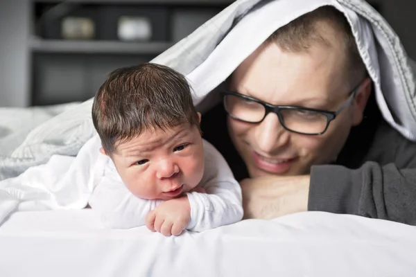 Bebê recém-nascido de duas semanas com pai na cama — Fotografia de Stock