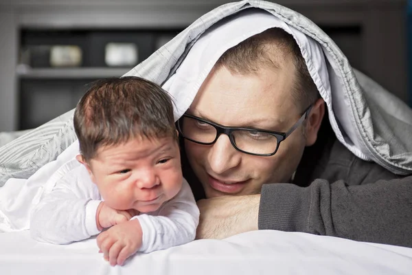 Dva týdny novorozené dítě s otcem v posteli — Stock fotografie