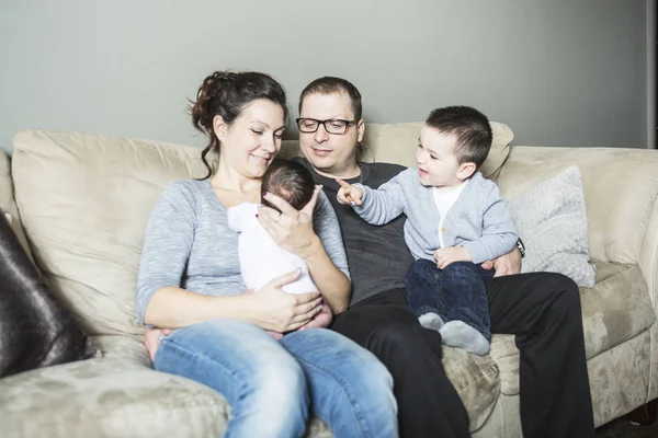 Mladá rodina se dvěma dětmi doma — Stock fotografie