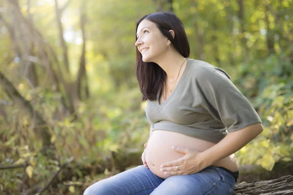 Beautiful pregnant woman relaxing on a park — Stock Photo, Image