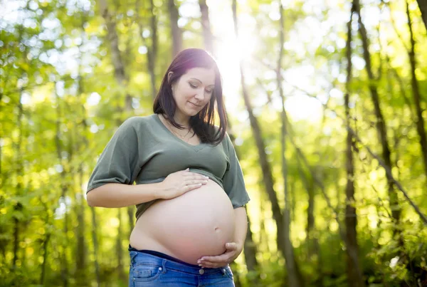 Piękna kobieta w ciąży relaks w parku — Zdjęcie stockowe