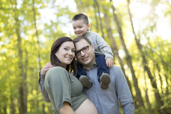 Happy pregnant family having fun in autumn nature — Stock Photo, Image