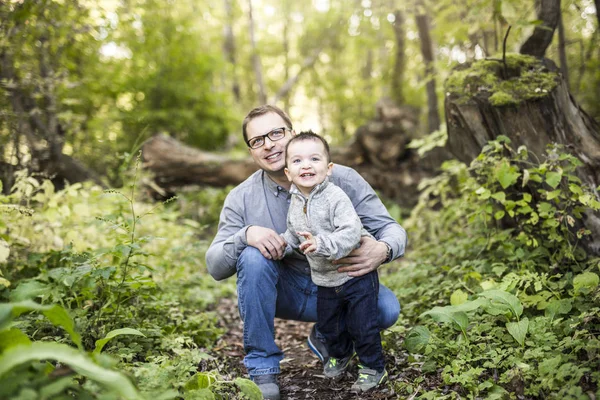 Petit garçon et son père sur l'herbe dans la forêt d'automne — Photo