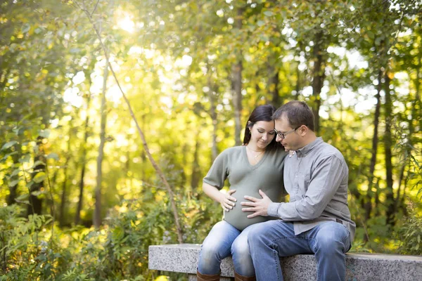 Hermosa pareja embarazada relajándose afuera en el parque . — Foto de Stock