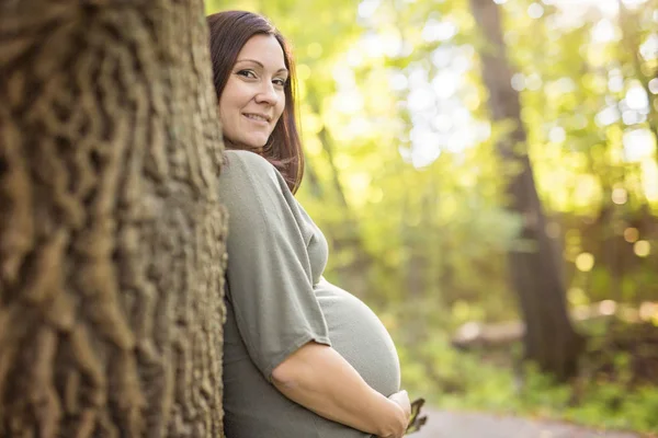 Güzel hamile kadın rahatlatıcı bir park üzerine — Stok fotoğraf