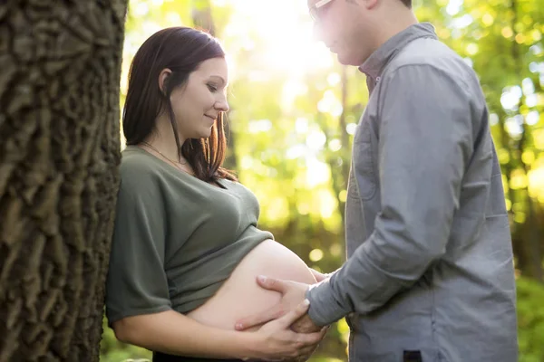 Vackra gravida par avkopplande utanför i parken. — Stockfoto