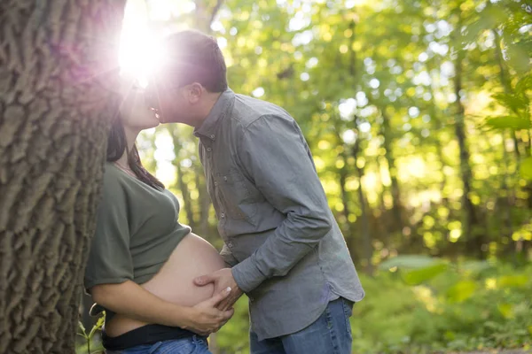 Casal grávida bonita relaxante lá fora no parque . — Fotografia de Stock