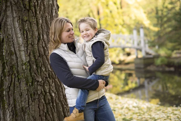 Entzückender kleiner Junge mit seiner Mutter im Herbstpark — Stockfoto