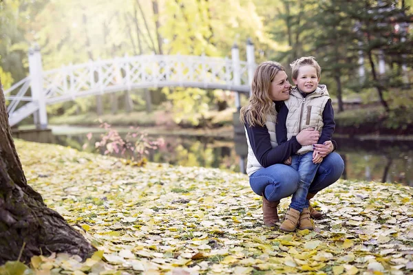 Adorable little boy with his mother in autumn park — Stock Photo, Image