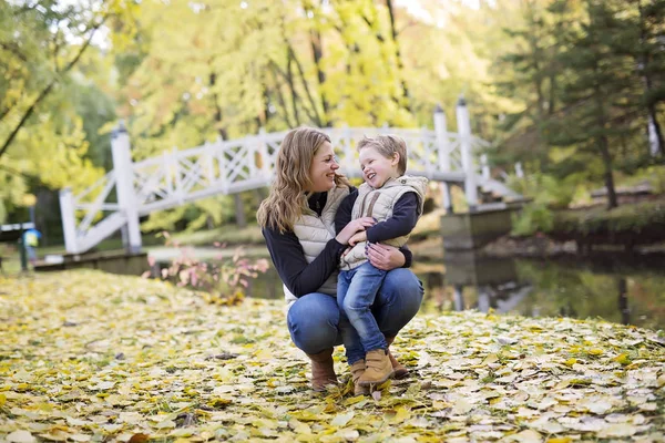 Adorable little boy with his mother in autumn park — Stock Photo, Image