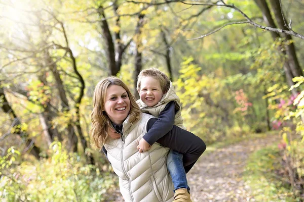 Adorable little boy with his mother in autumn park — Stock Photo, Image