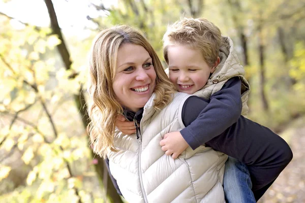Bedårande liten pojke med sin mamma i höst park — Stockfoto