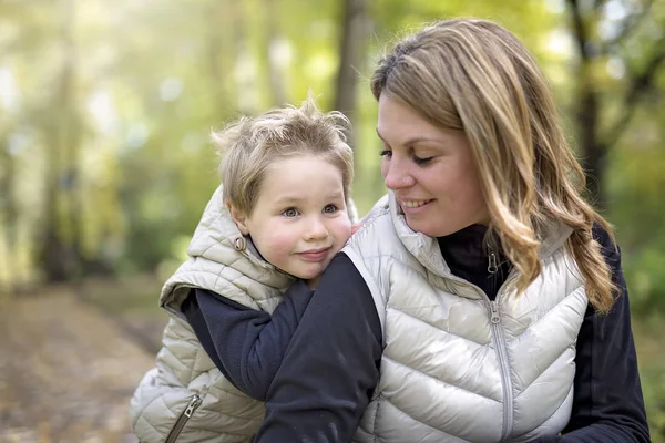 Bedårande liten pojke med sin mamma i höst park — Stockfoto