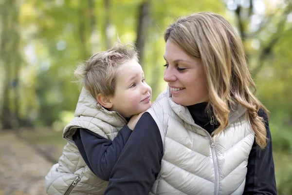 Adorabile bambino con sua madre nel parco autunnale — Foto Stock