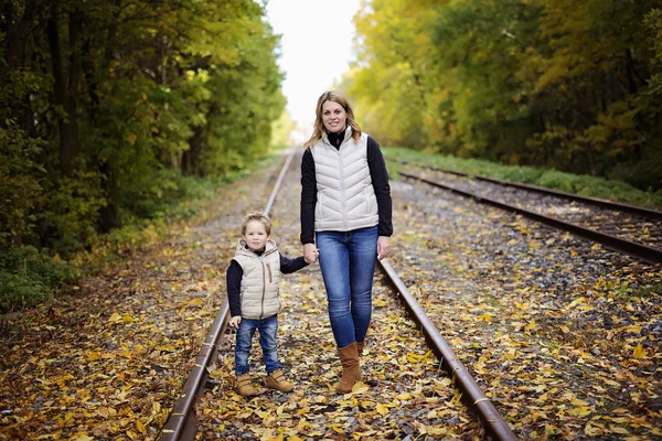 Adorable little boy with his mother in autumn park — Stock Photo, Image