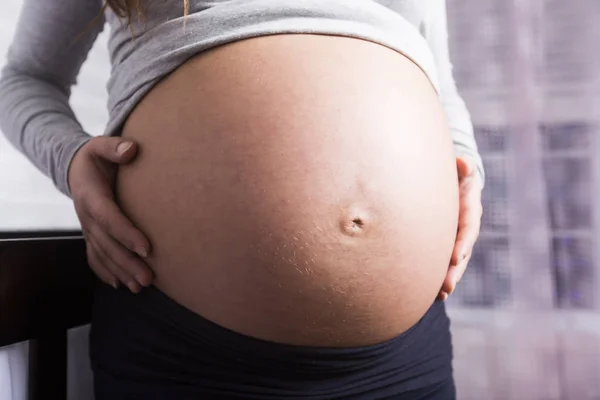 Mujer embarazada en habitación de bebé — Foto de Stock