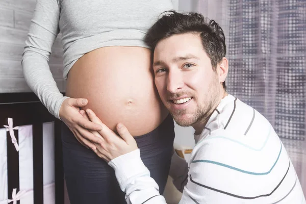 Mãe grávida e seu marido no quarto de bebê — Fotografia de Stock