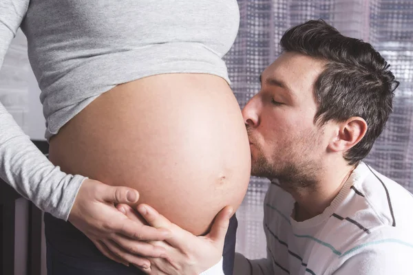 Беременная мать и ее муж в детской комнате — стоковое фото