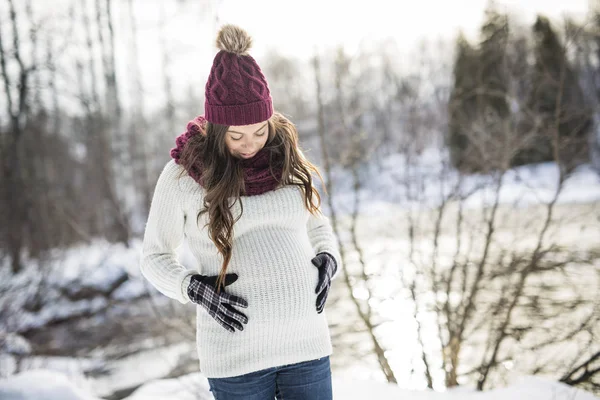 Young happy pregnant woman in snowy forest — Stock Photo, Image