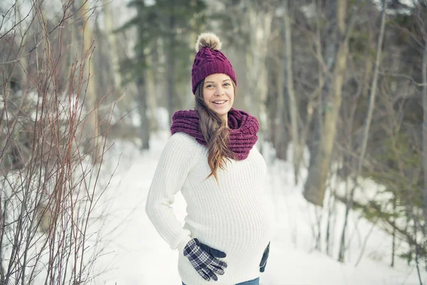 Jeune femme enceinte heureuse dans la forêt enneigée — Photo
