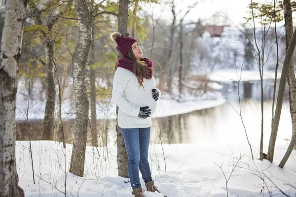 Young happy pregnant woman in snowy forest — Stock Photo, Image