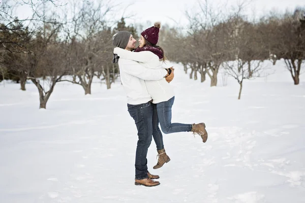 Беременная пара веселится зимой на природе — стоковое фото
