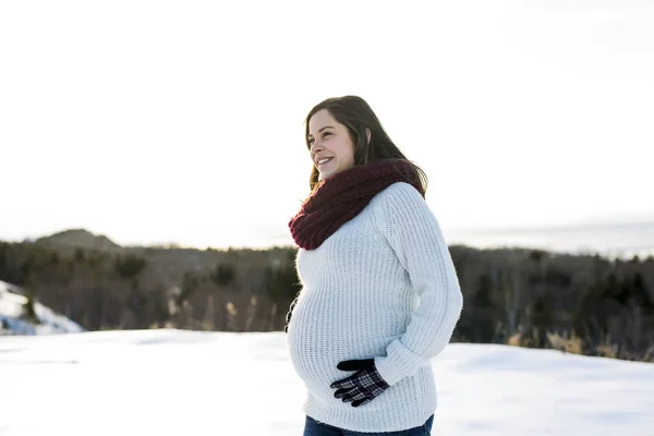 Young happy pregnant woman in snowy forest — Stock Photo, Image