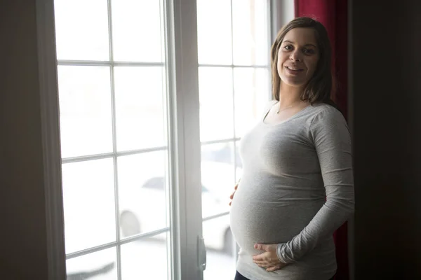 Young pregnant woman close to the window — Stock Photo, Image