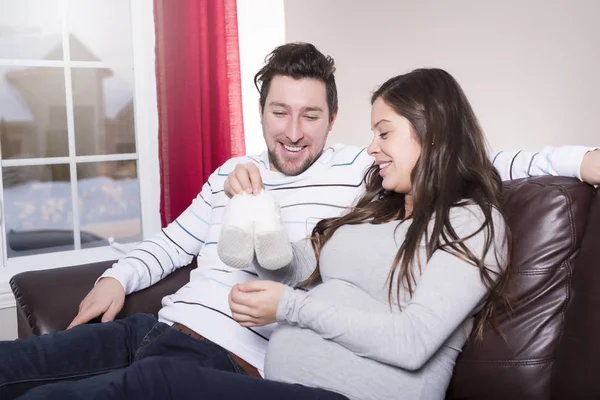 Femme mi-adulte attendant bébé couché sur le canapé — Photo