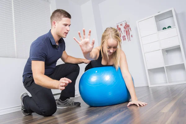 Fisioterapeuta masculino y mujer ayudando al paciente — Foto de Stock