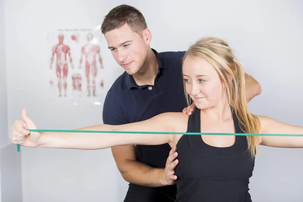 Fisioterapeuta masculino y mujer ayudando al paciente — Foto de Stock