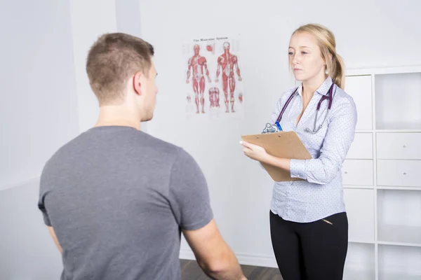 Medico esaminando il suo paziente in studio medico — Foto Stock