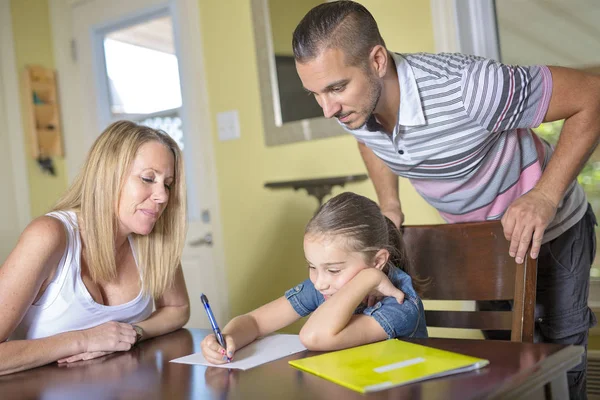 Genitori aiutare il figlio con i compiti a casa interni — Foto Stock
