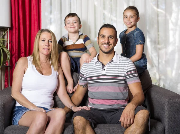 Família de quatro pessoas no sofá da sala de estar — Fotografia de Stock