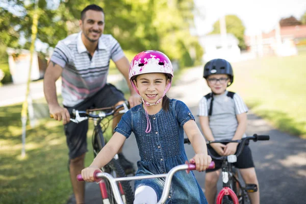 Papa avec fille fils équitation vélos dans le parc — Photo