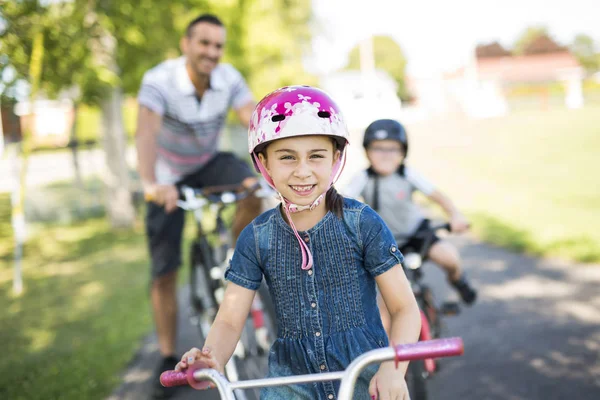 Papà con figlia figlio andare in bicicletta nel parco — Foto Stock